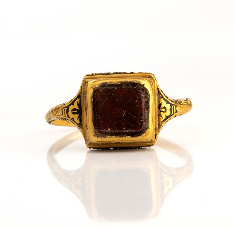 A Late Renaissanace gold and black enamel ring set with a garnet.