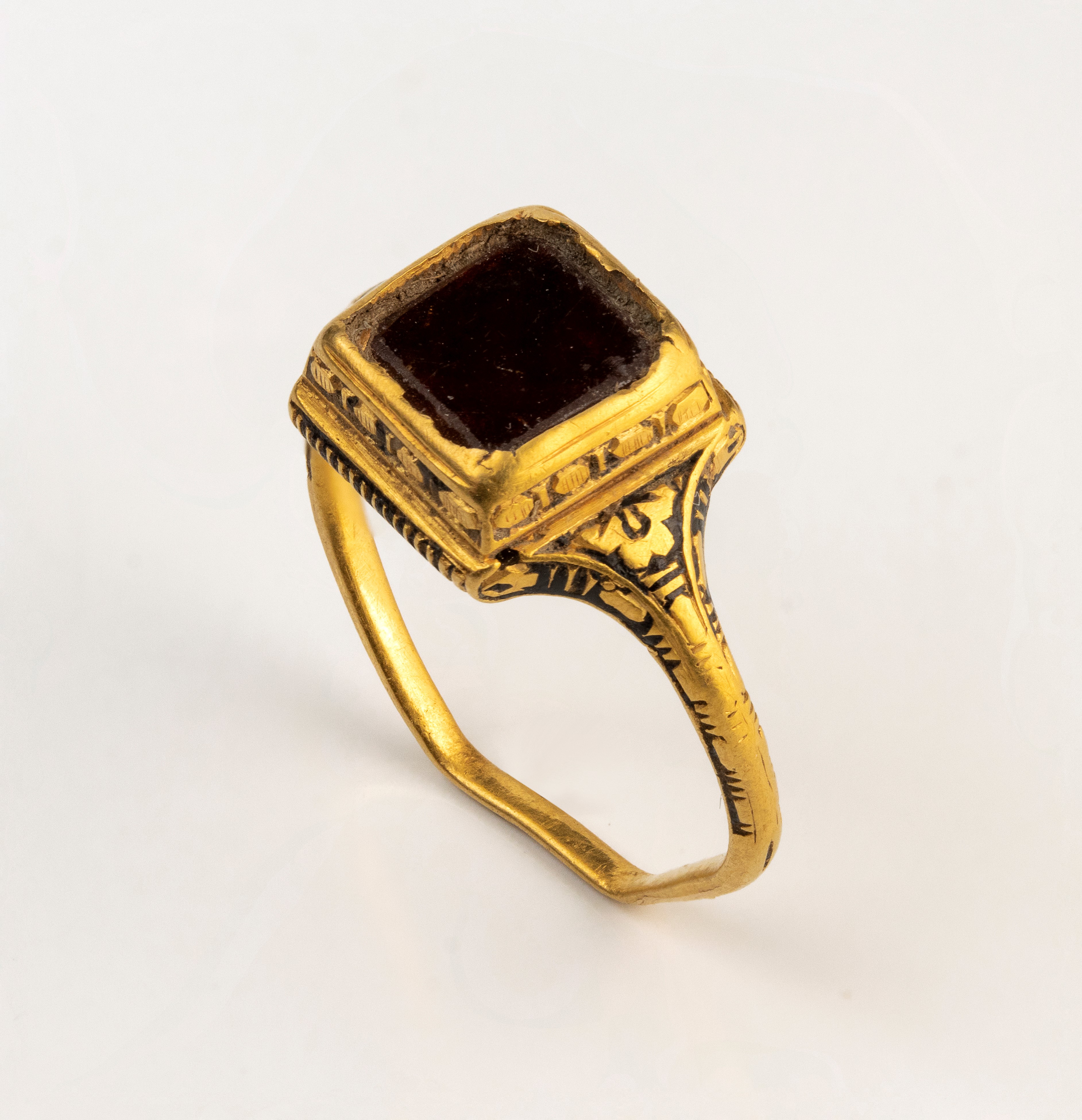 A Late Renaissanace gold and black enamel ring set with a garnet.