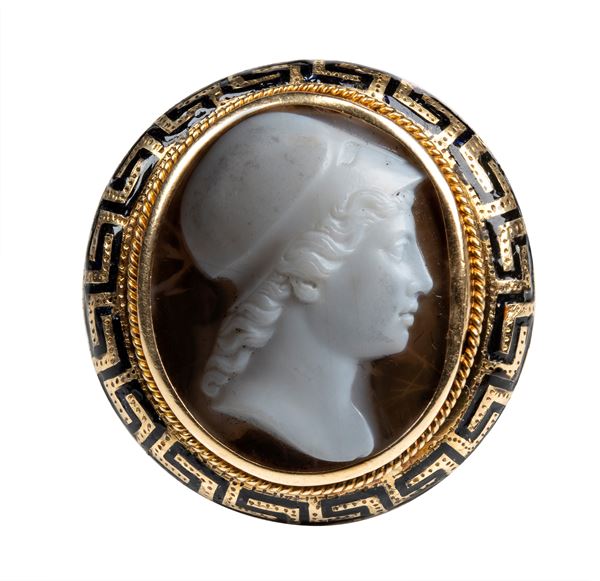 A Neoclassical agate cameo set in a gold and black enamel ring.