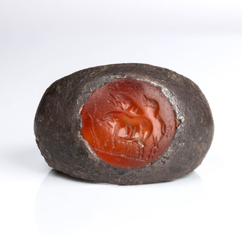 A Roman carnelian intaglio set in a silver ring. Three pigs.