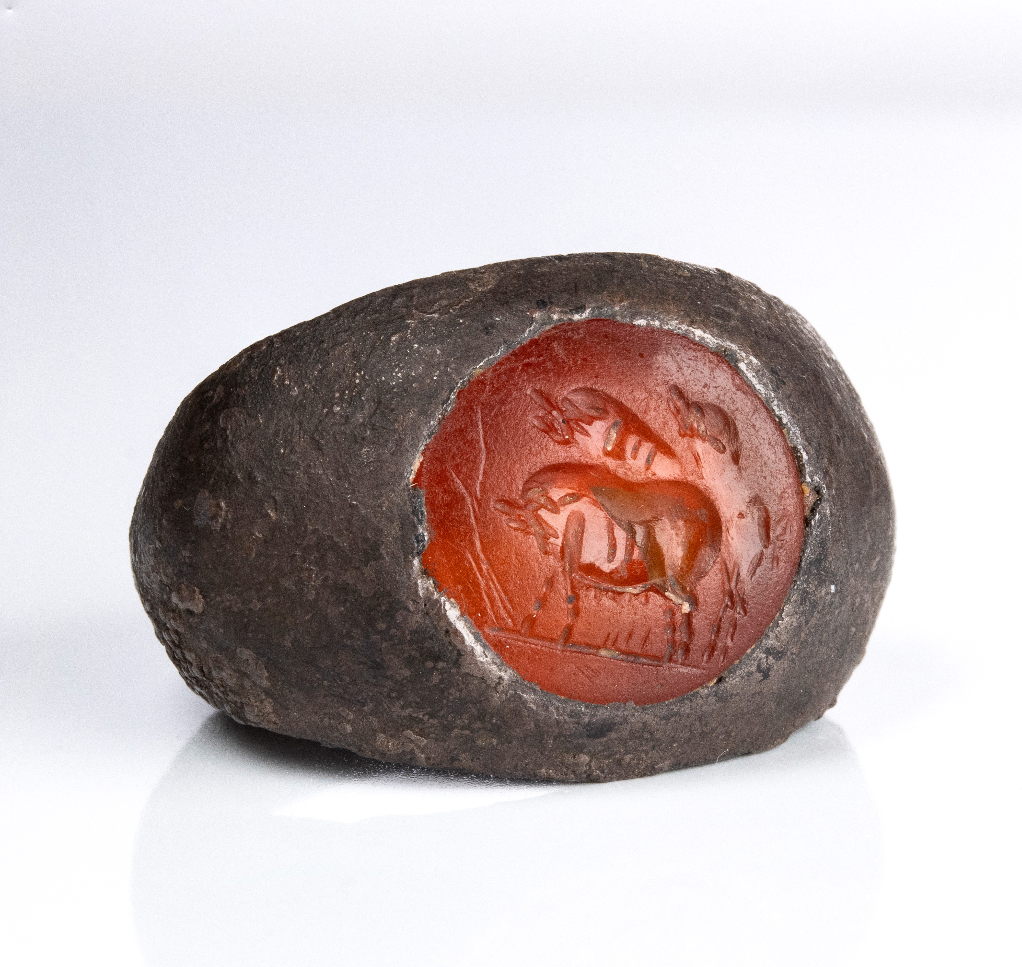 A Roman carnelian intaglio set in a silver ring. Three pigs.