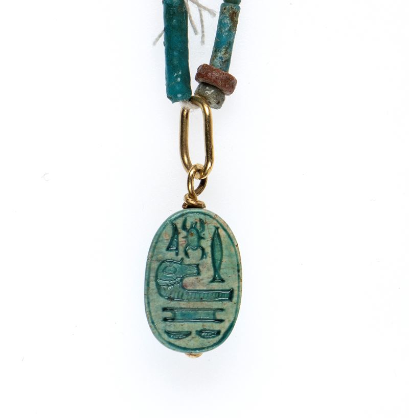 A Restrung New Kingdom faience necklace with an engraved scarab.