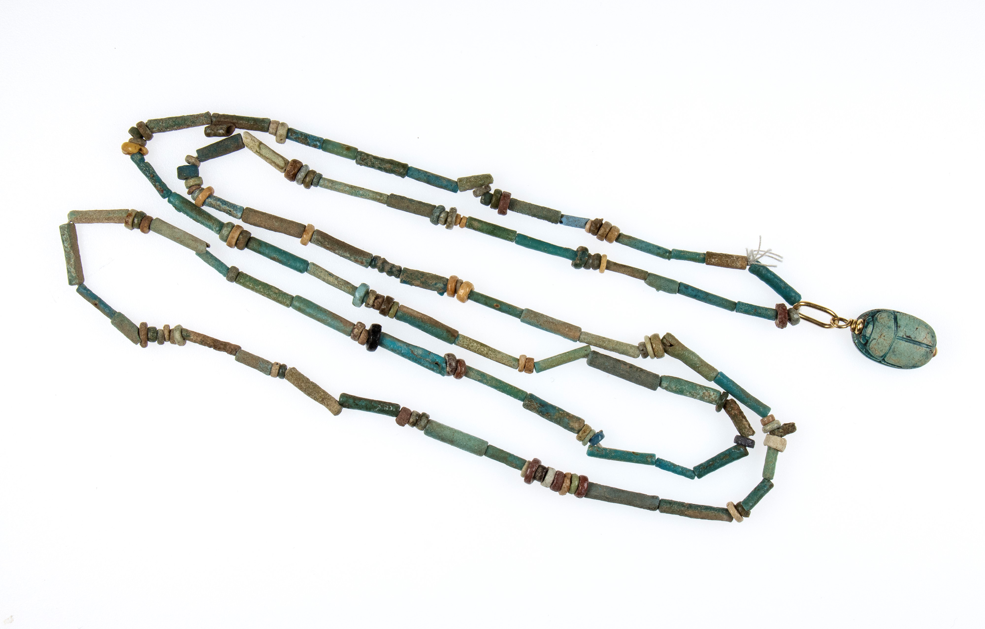 A Restrung New Kingdom faience necklace with an engraved scarab.