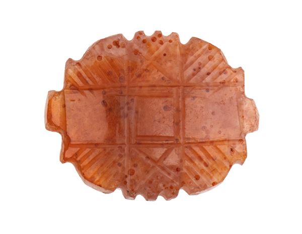 A Western Asia carnelian stylized amulet.