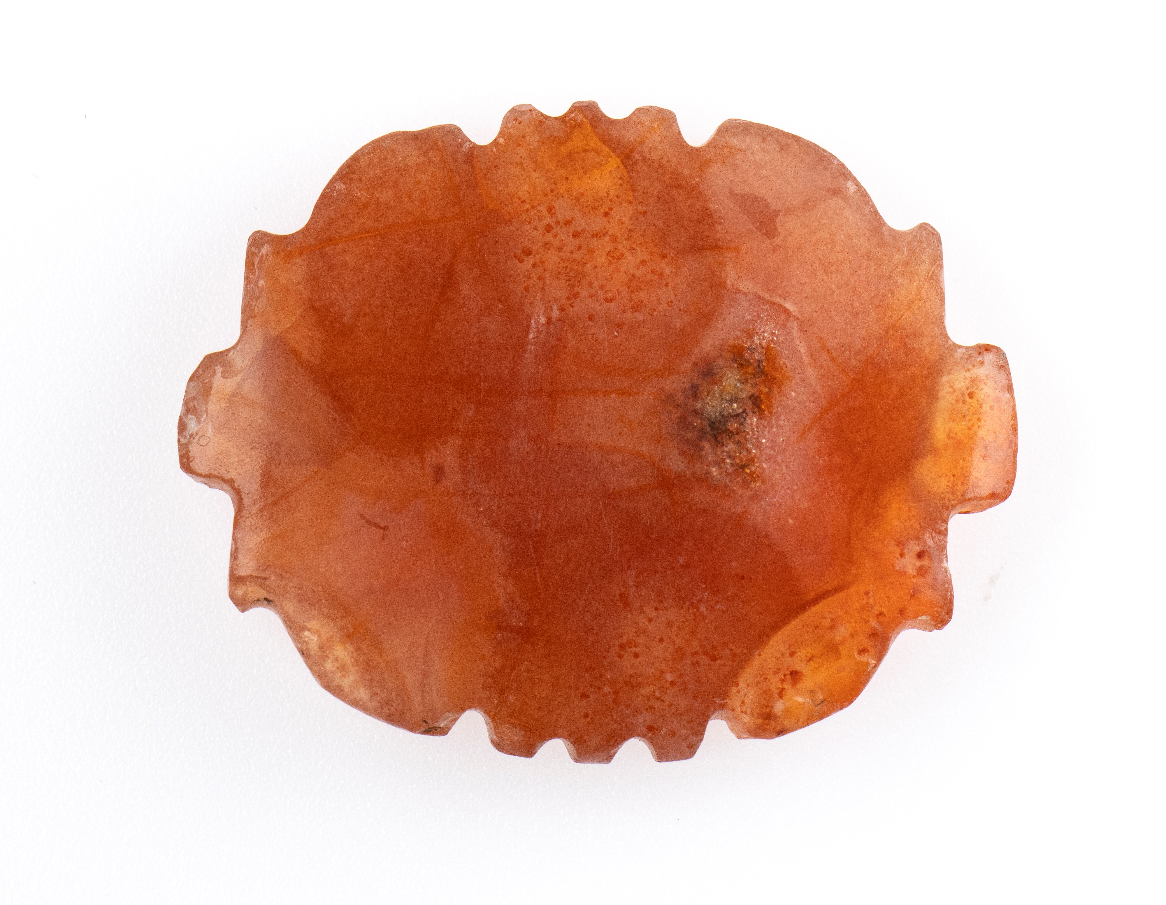 A Western Asia carnelian stylized amulet.