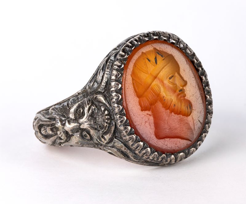 A postclassical carnelian intaglio set in a later silver ring. Male head.