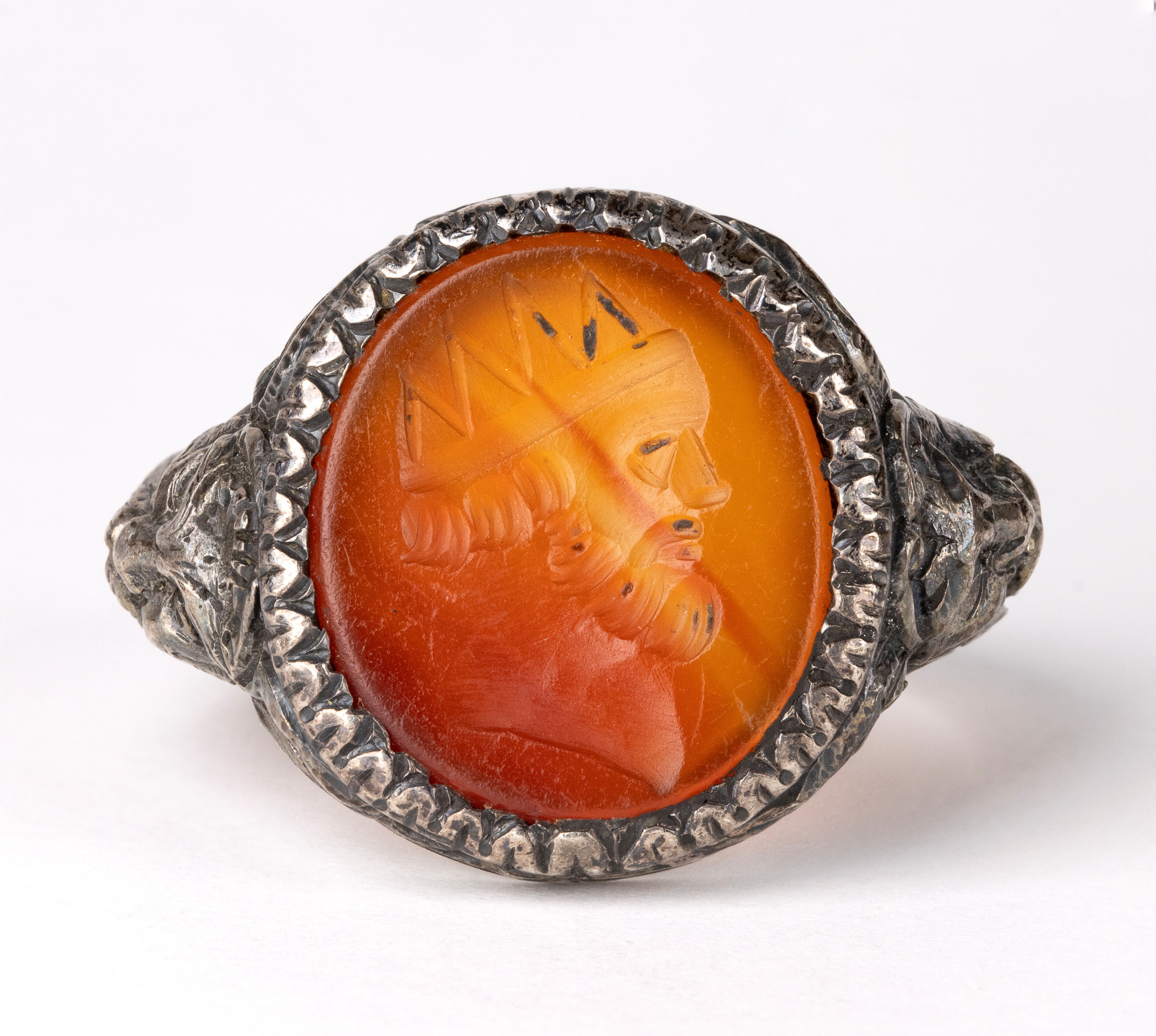 A postclassical carnelian intaglio set in a later silver ring. Male head.