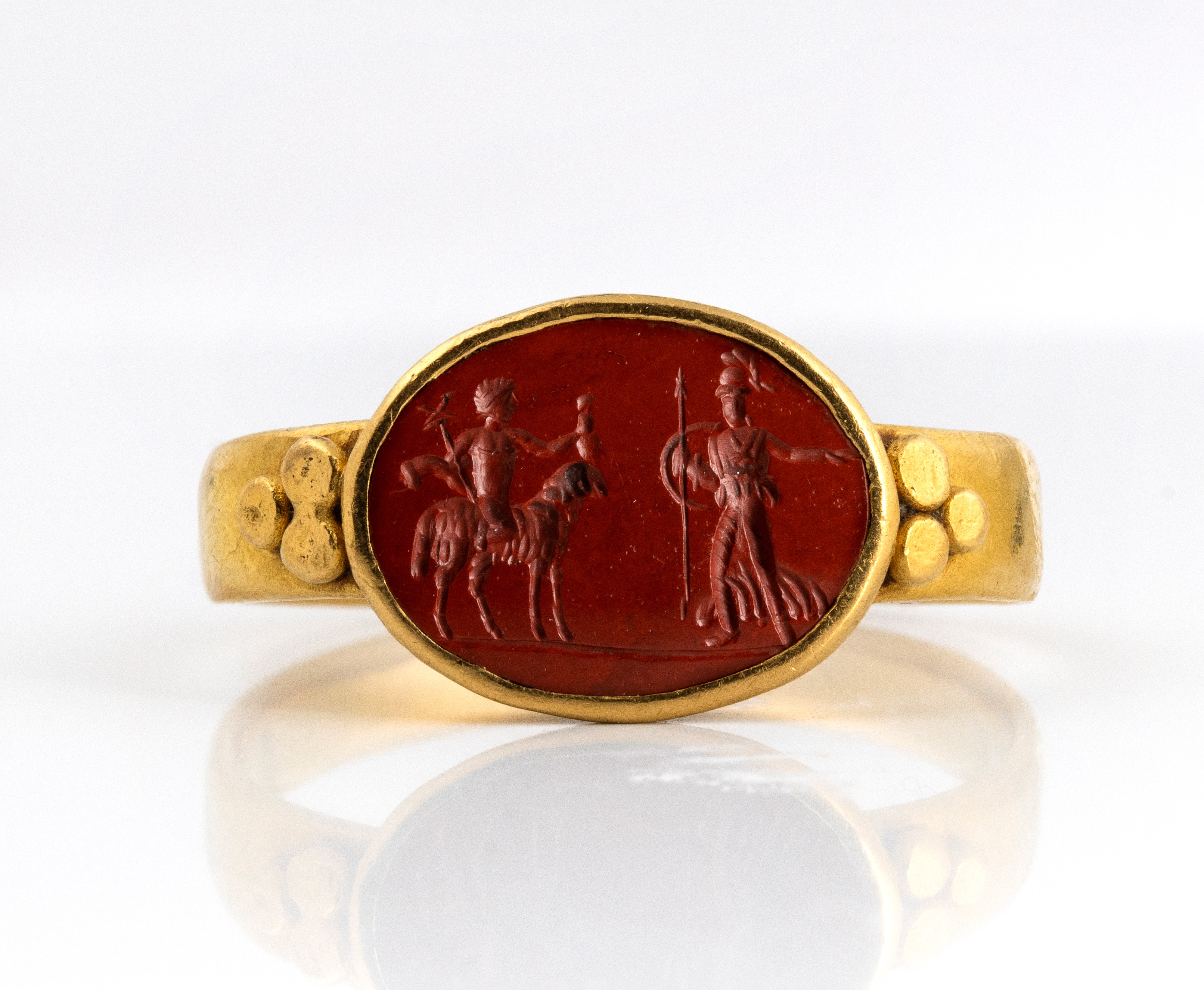 A Roman gold ring set with a red jasper intaglio. Hermes and Athena.