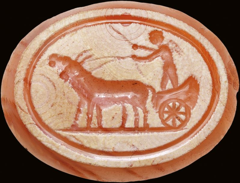 A partially burnt agate intaglio. Erote on a chariot drawn by two goats.