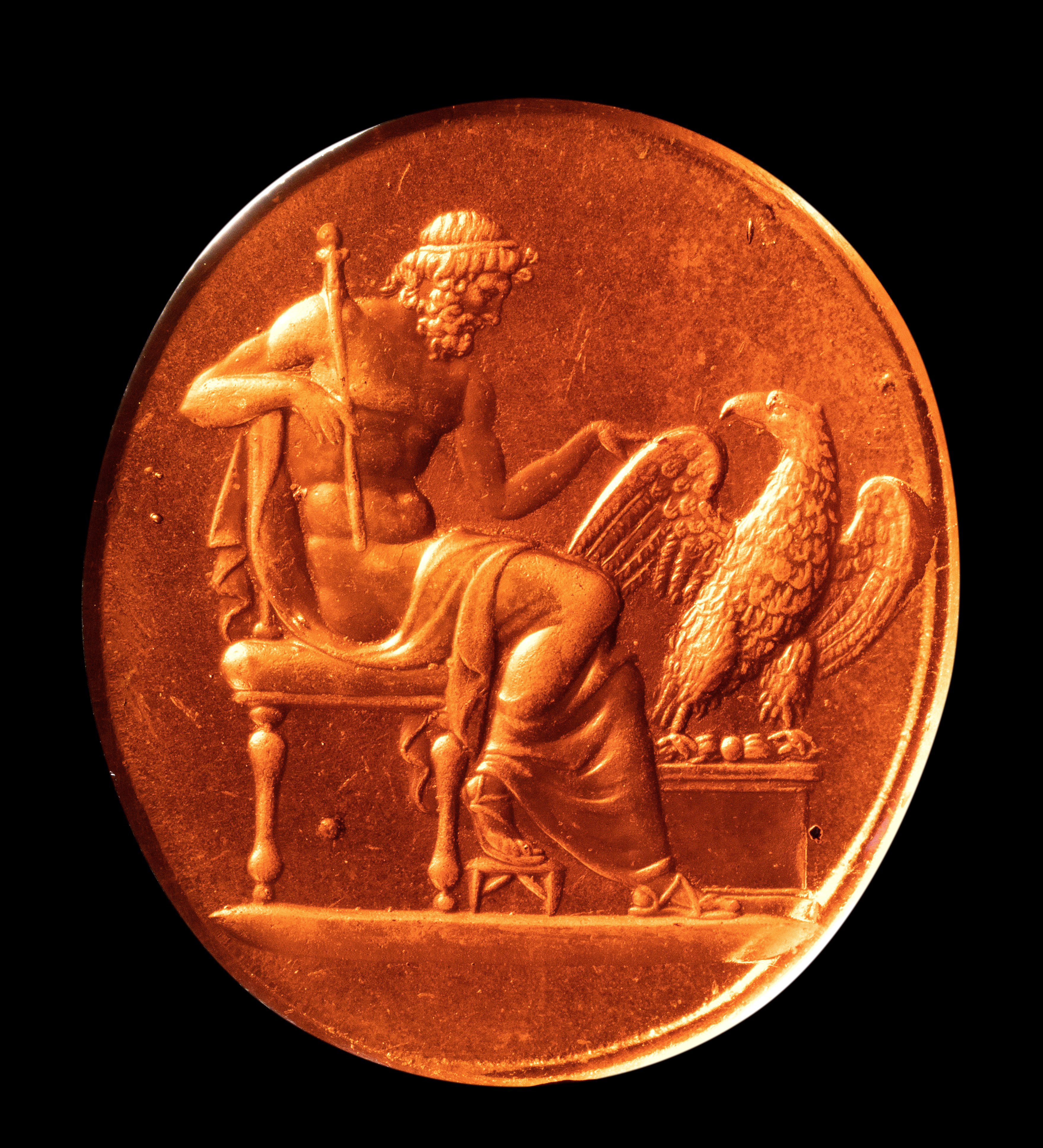 A large Grand Tour reddish brown glass cast impression. Jupiter sitting with the eagle.