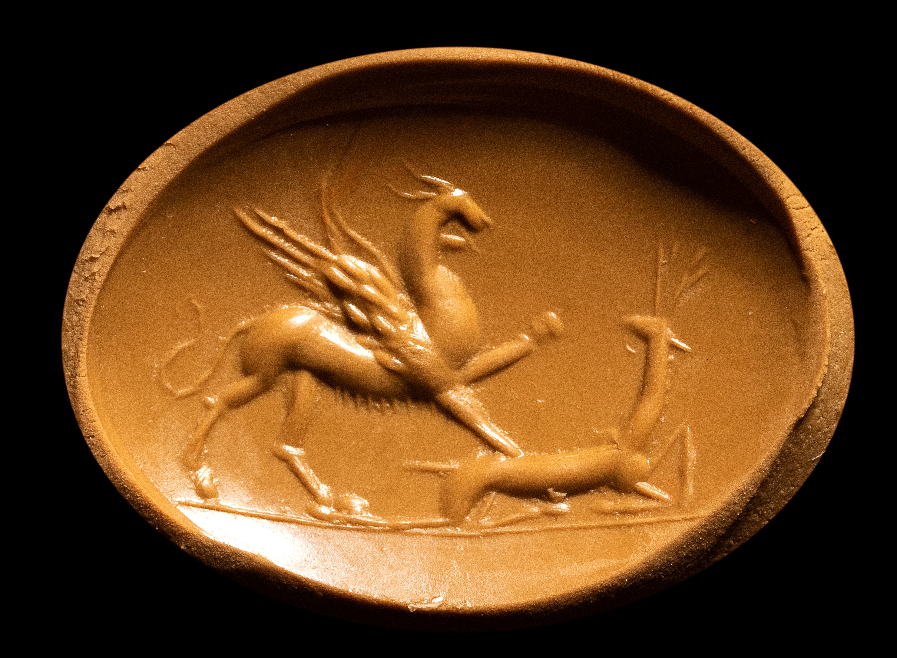 A Roman carnelian intaglio. Griffin with deer.