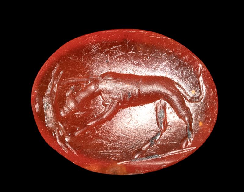 A Roman carnelian intaglio. Dog with prey.