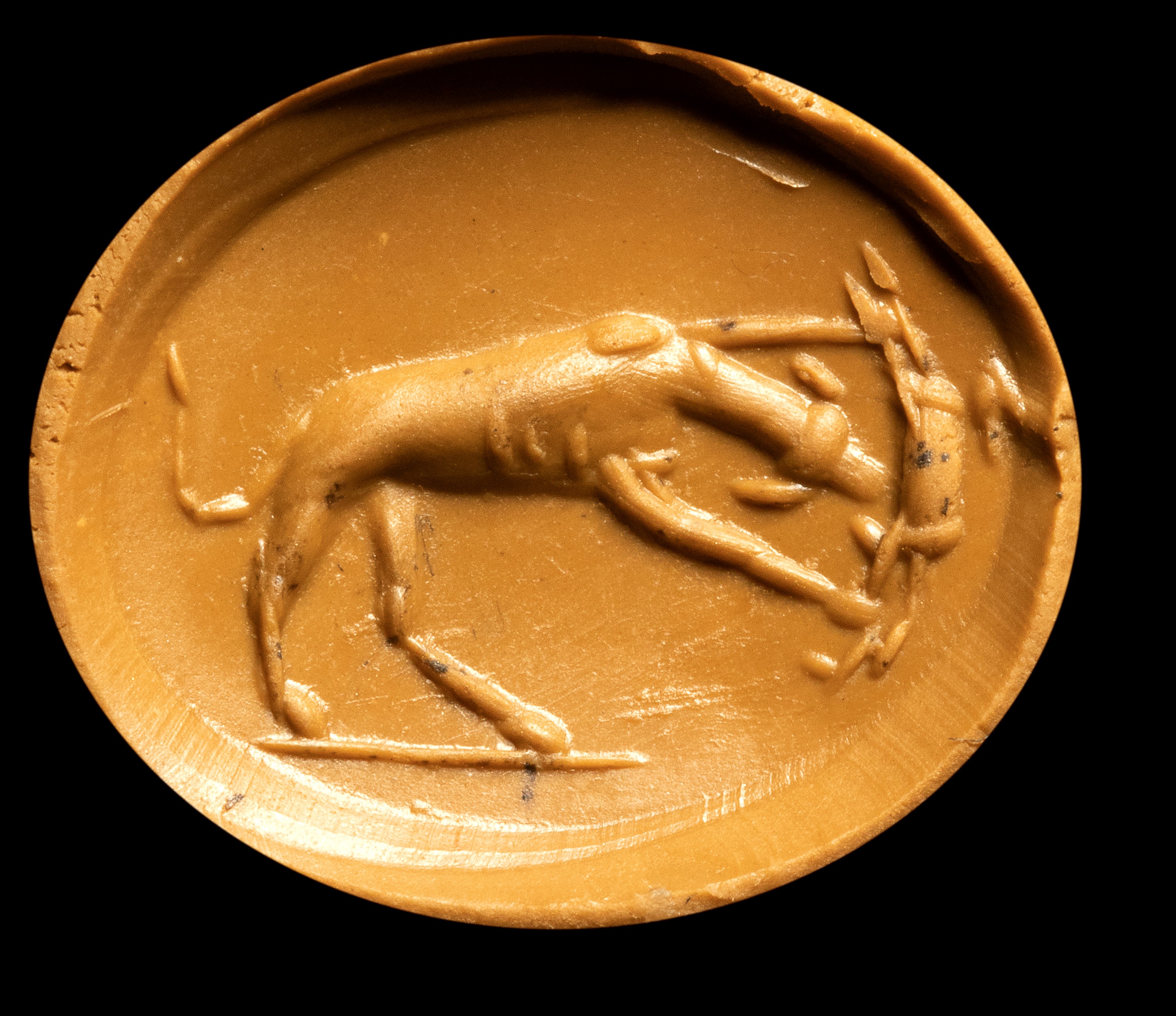 A Roman carnelian intaglio. Dog with prey.