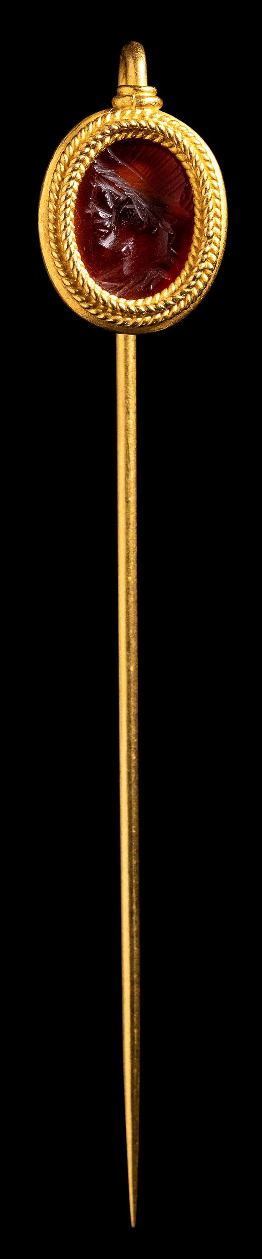 A Roman carnelian intaglio set in a gold stick pin. Apollo.