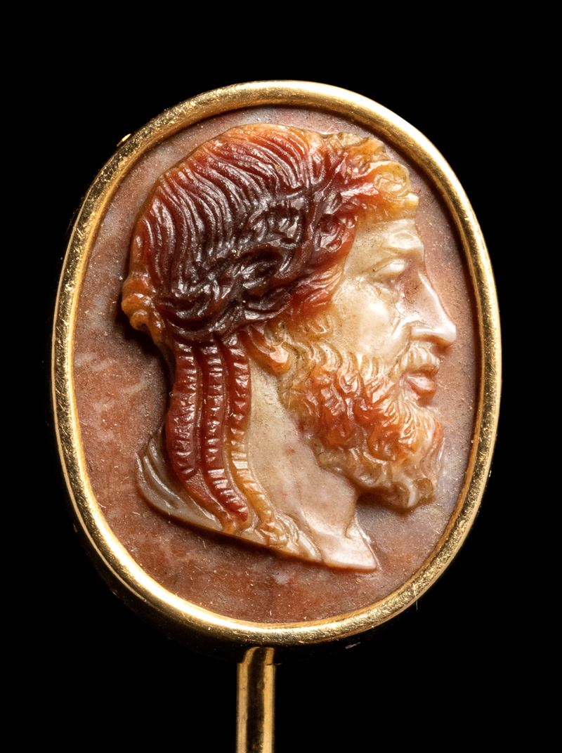 A three-layered agate cameo set in a gold stick pin. Bust of Zeus.
