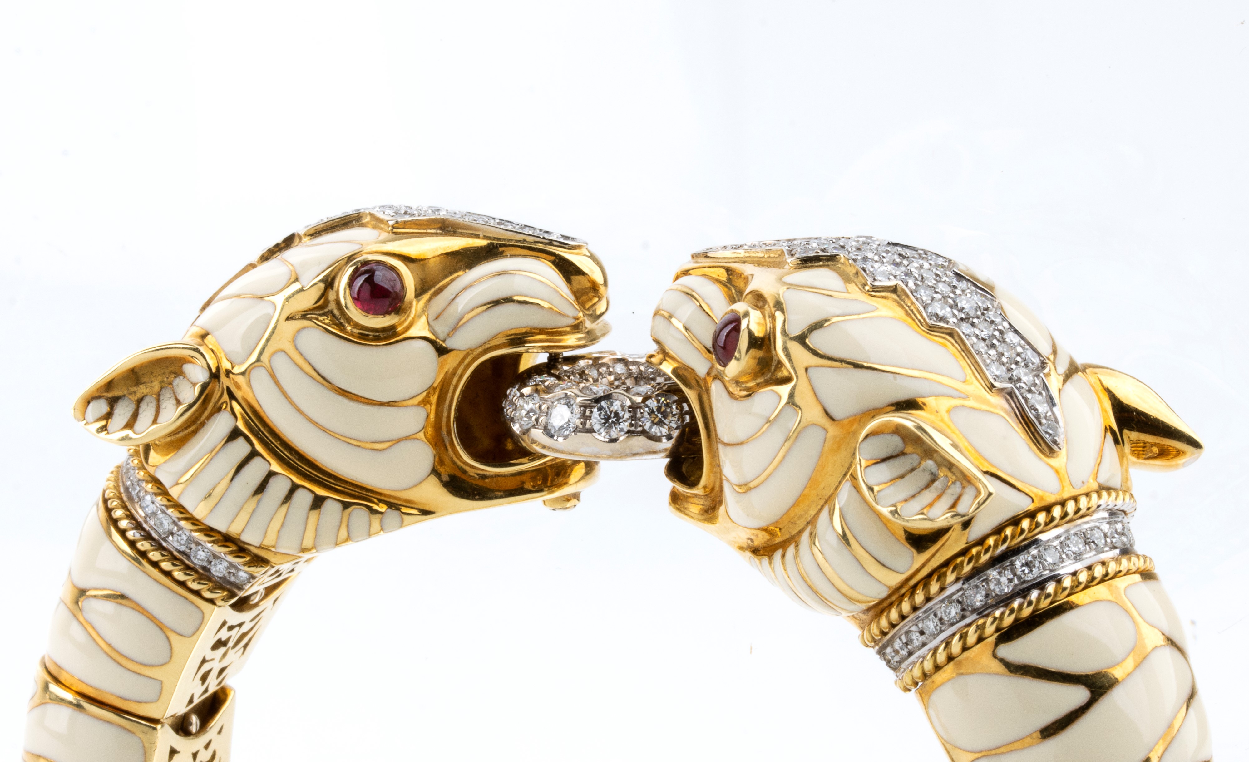 Bracciale flessibile in oro con coppia di teste di tigre, smalto bianco, rubini e diamanti